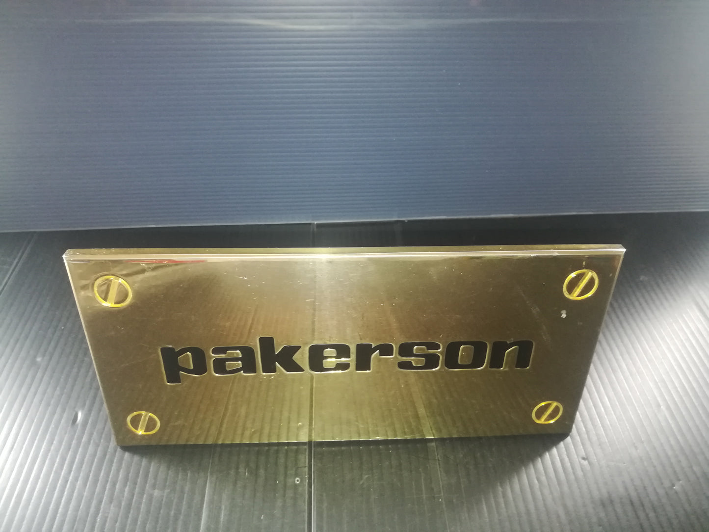 Pakerson Advertising Plaque In Golden Metal